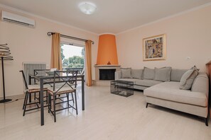 Leilighet – deluxe | Oppholdsområde | En 50-tommers Flatskjerm-TV med Parabol-TV samt TV og peis