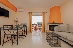 Deluxe appartement | Woonruimte | Een 50-inch flatscreentelevisie met satellietzenders en televisie