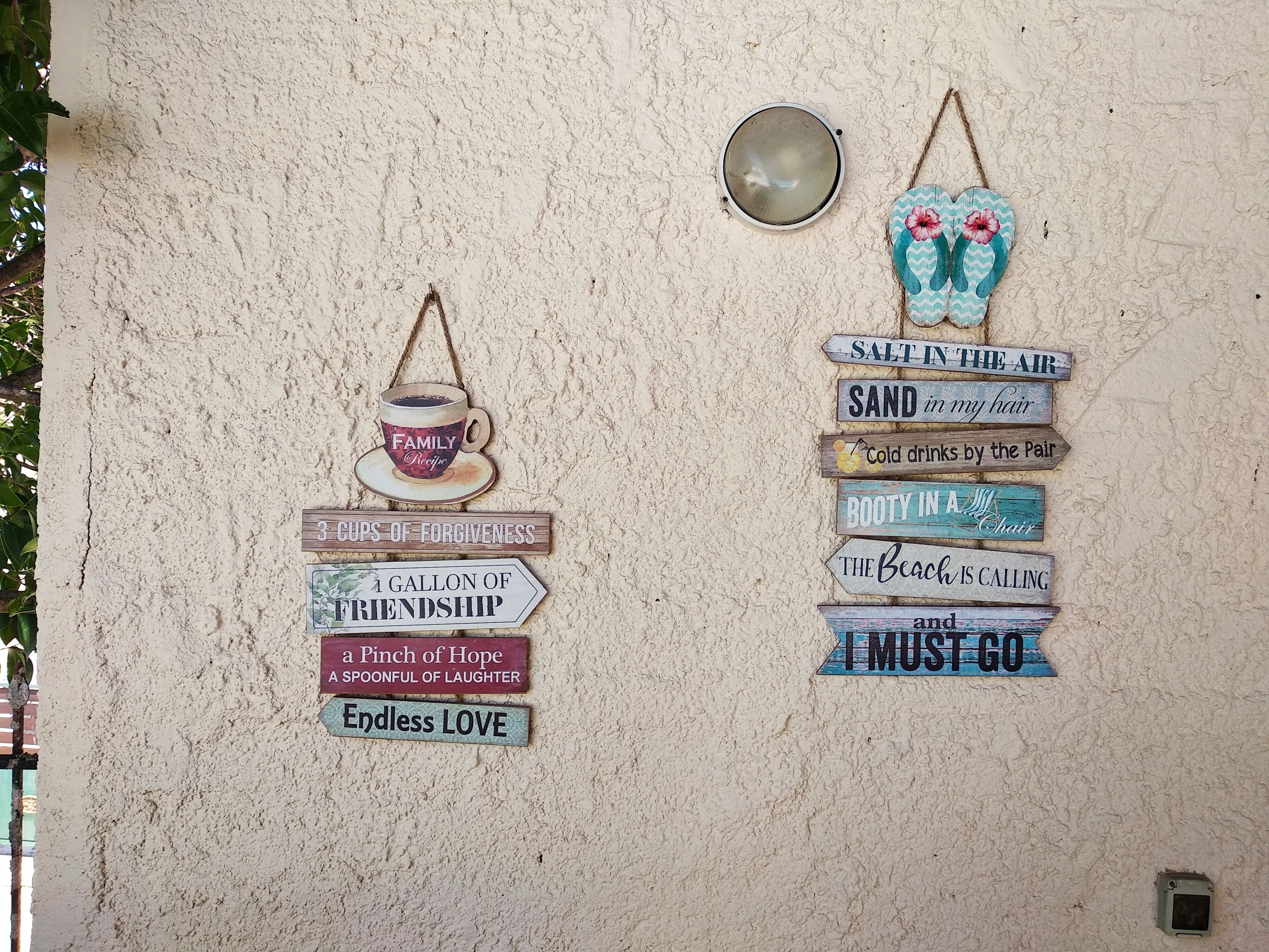 Un mur orné de différents panneaux et sur lequel est suspendu un luminaire.