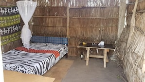 A room with a bed, a table, and a mosquito net. - Mida Creek Nature Camp (Watamu)
