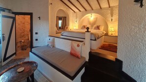 A bedroom with a bed, a small table, and a bathroom with a shower. - Polonezköy Country Club & Accommodation in the Wildlife Park (Beykoz)