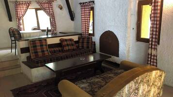 A cozy room with a sofa set, a coffee table, and a patterned rug.