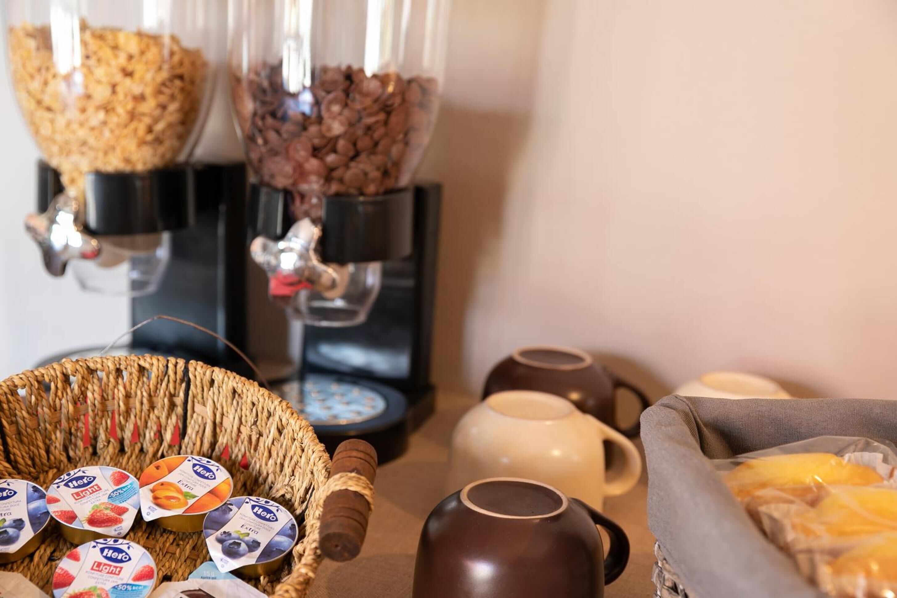 Un coin café équipé de deux distributeurs, un panier de pots de yaourt et un autre de viennoiseries.