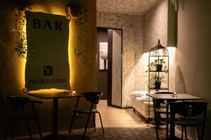 A cozy bar area with a sign reading "BAR PICCOLA CUCINA" and a small seating area with a table and chairs. - Hotel Del Corso (Borgomanero)