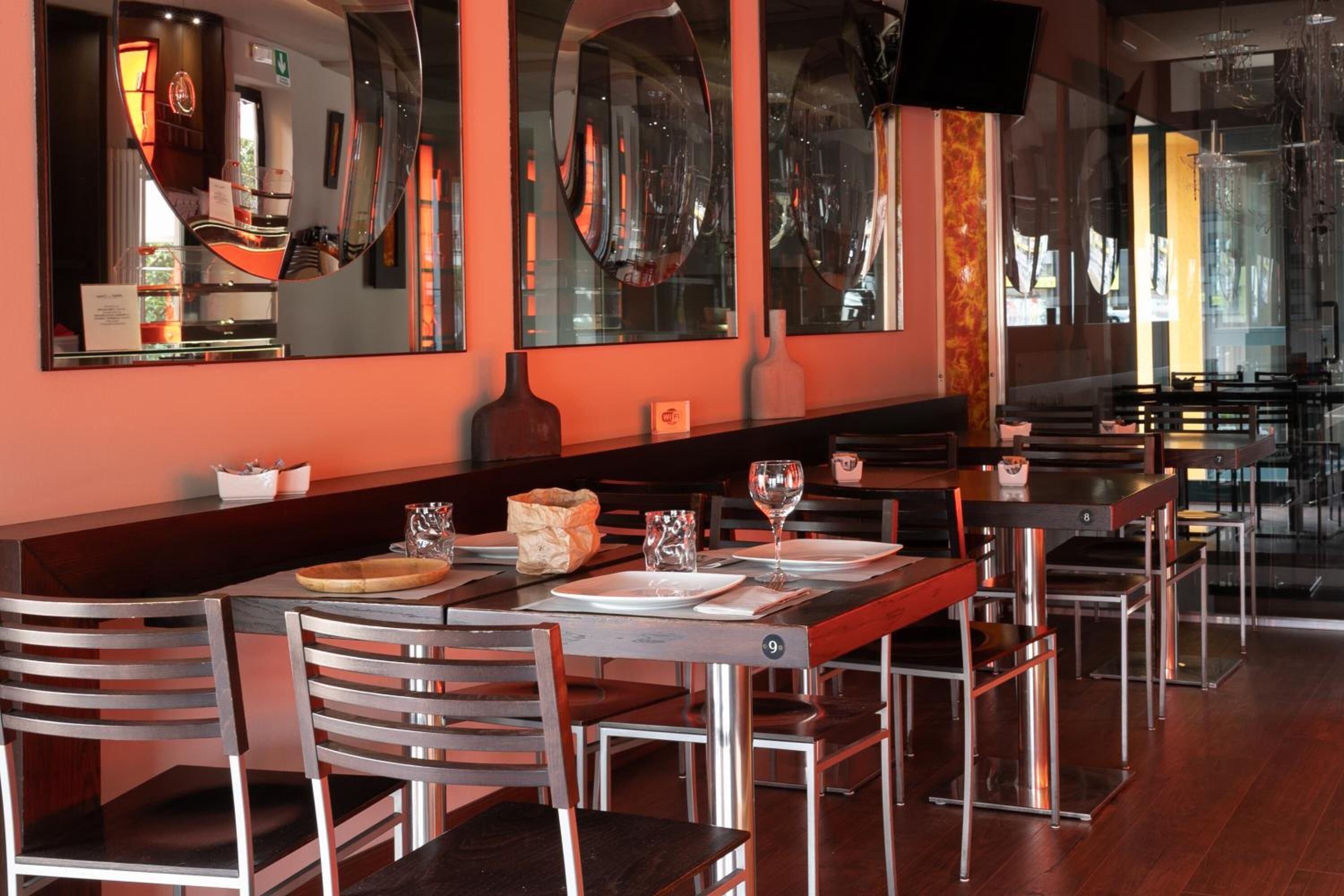 Ein Restaurant mit einer langen Theke, mehreren Tischen und Stühlen.