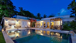 A swimming pool with lounge chairs and a covered patio area. - Tropical Oasis with Pool Near Beach - Todmorden (Gibbes Beach)