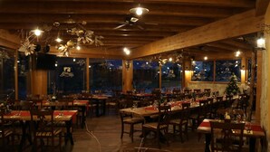 A restaurant with wooden beams, multiple tables, and chairs. - Guesthouse Gorska Reka (Zrece)