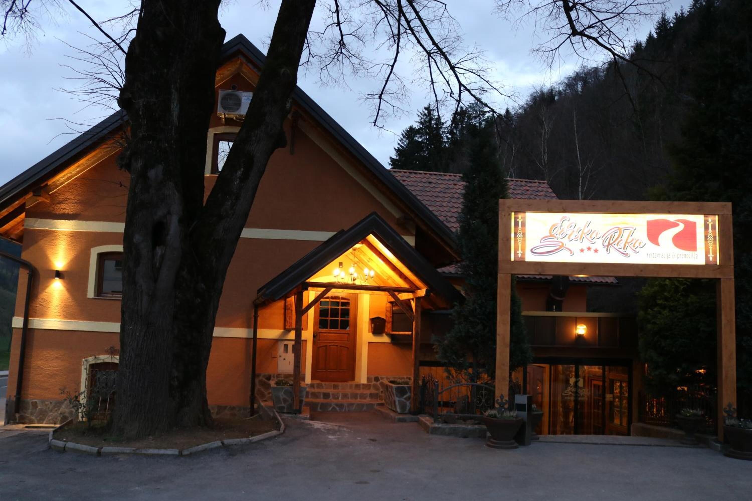 A lodge with a warm exterior, a wooden entrance, and a signboard.