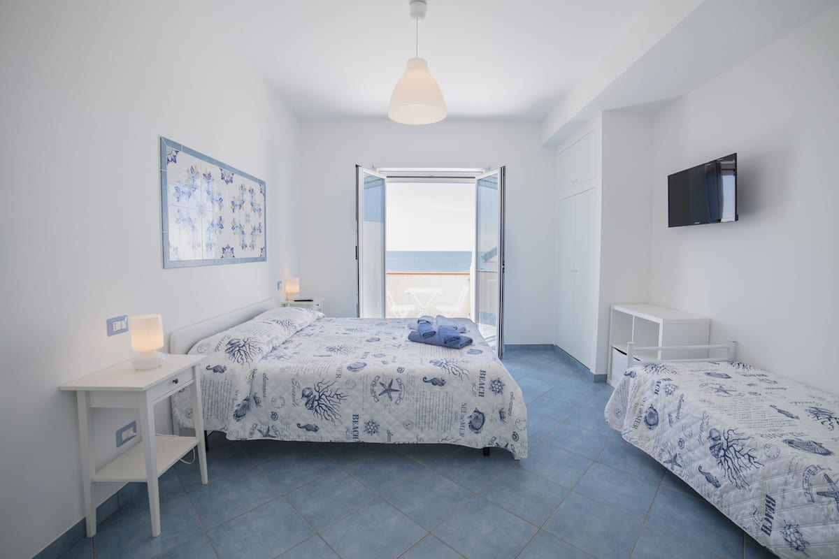A bedroom with a bed, bedside table, and a TV.