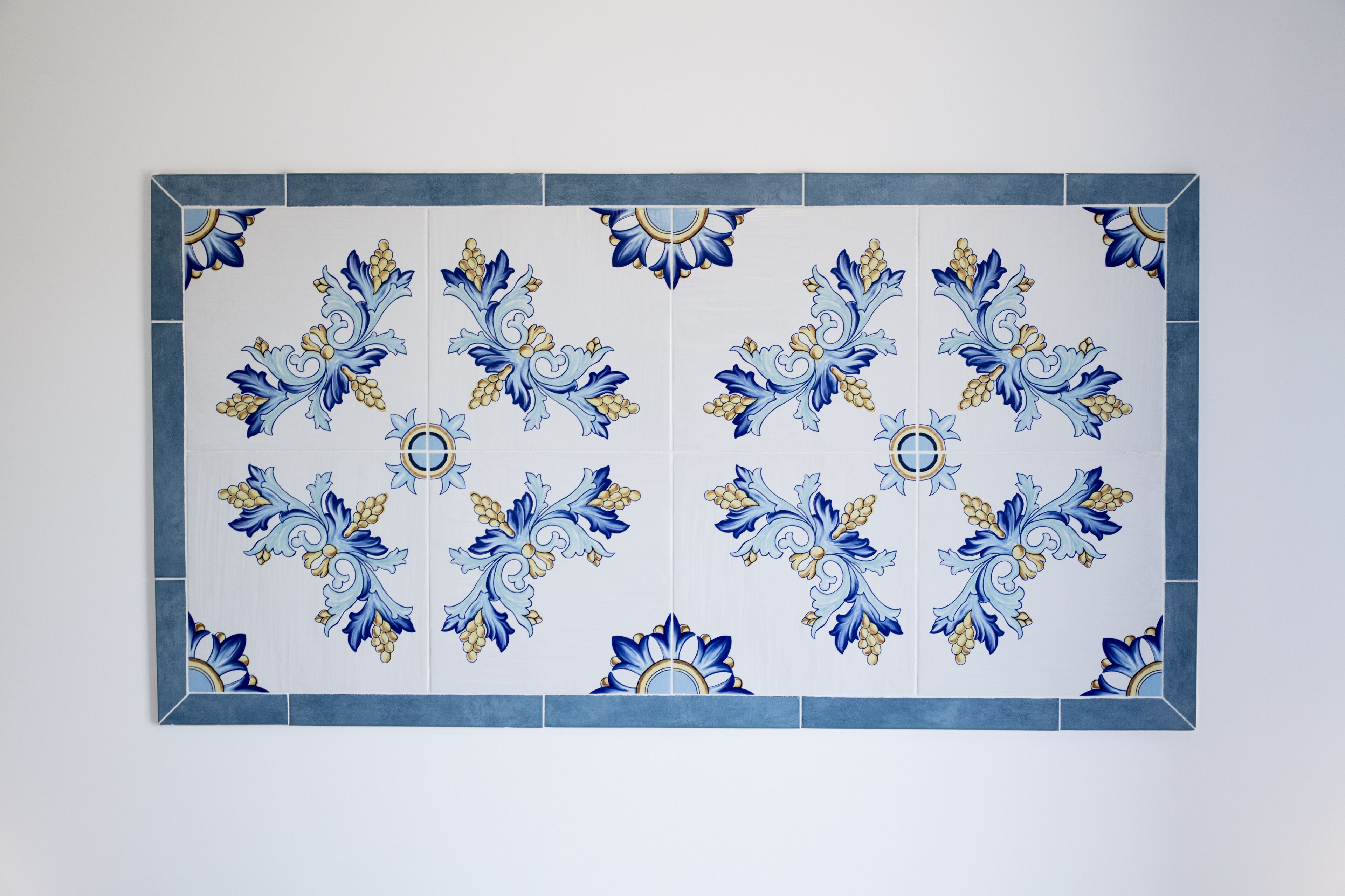 Un mur recouvert de carreaux formant un motif floral symétrique.