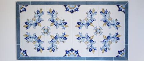 Un mur recouvert de carreaux formant un motif floral symétrique.
