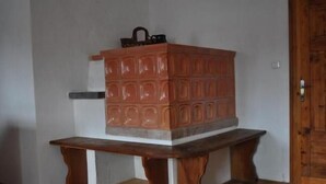 Um armário de madeira com puxador na parte superior, apoiado em um banco de madeira com base branca.