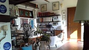 A cozy living room with a fireplace, bookshelves, and a comfortable seating area. - Villa Malgrè Tout (Bonvicino)