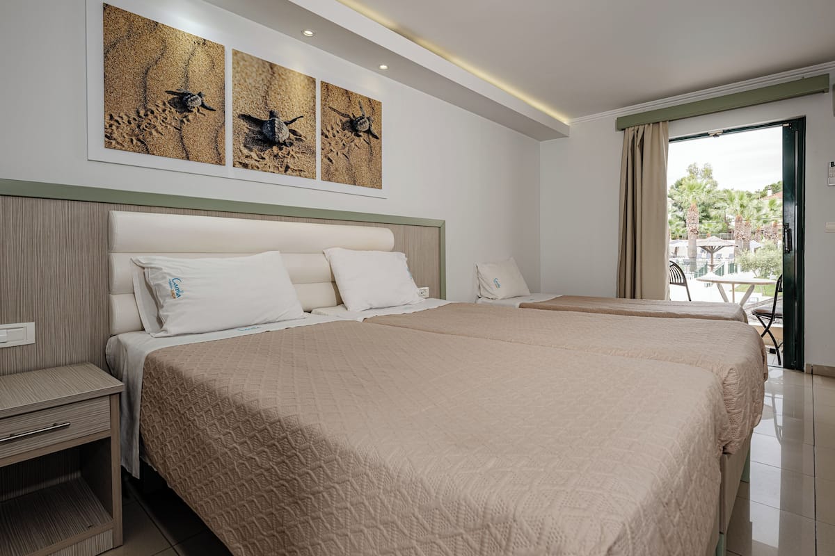 A hotel room with two beds, a nightstand, a wall-mounted artwork, and a view of the outdoors.