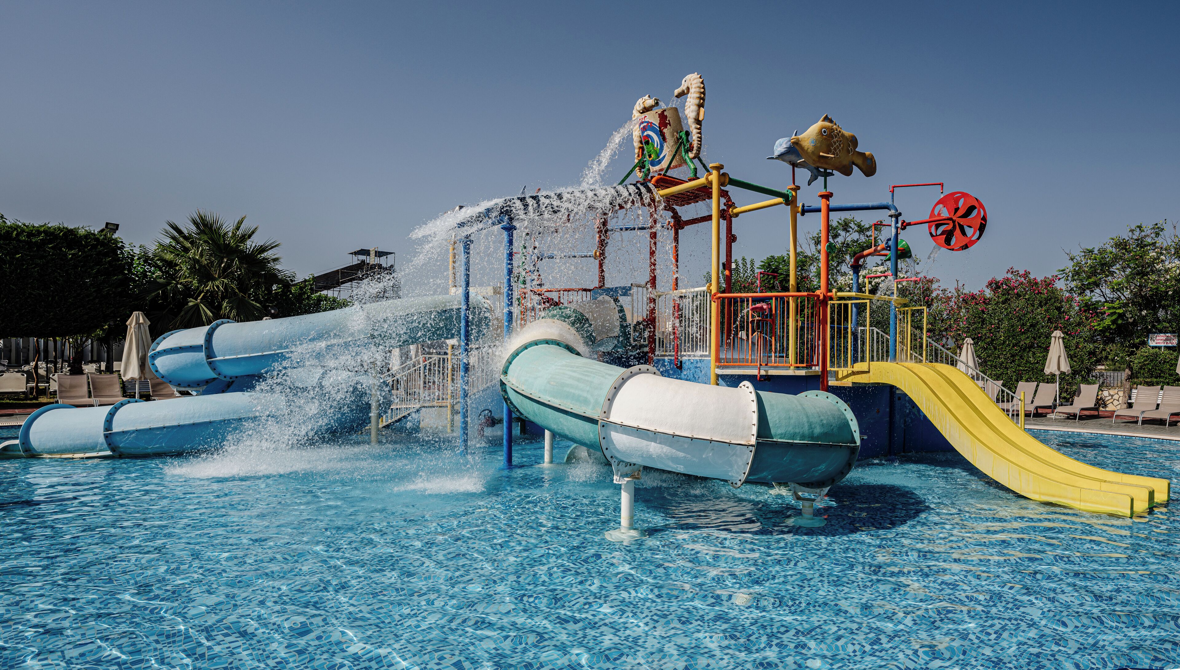 A water park with a large pool, slides, and play structures.