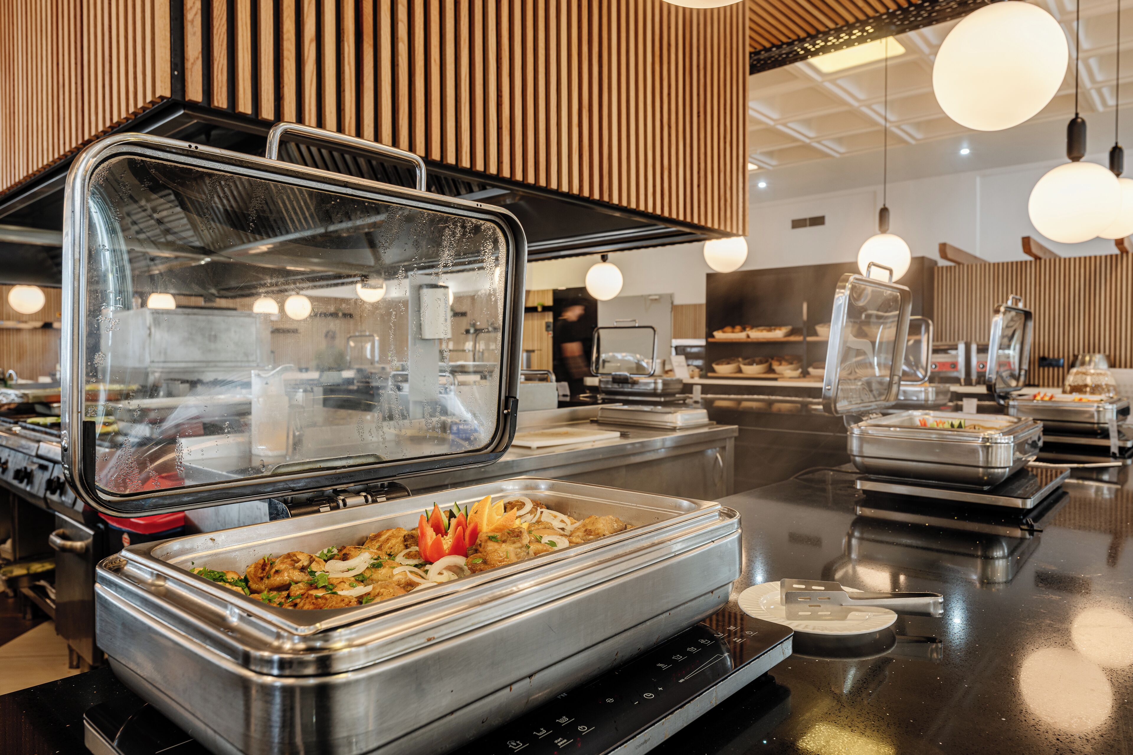 Disposição de buffet com diversos alimentos e um respiradouro a vapor.