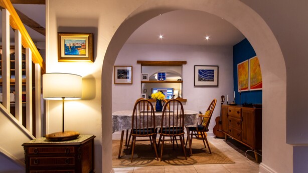A dining area with a table, chairs, and a lamp. - 3 bedroom  family friendly and pet friendly cottage in Narberth, Pembrokeshire (Narberth)