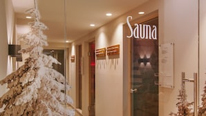 A hallway with a sign reading "Sauna" and a decorative white tree. - Hotel Chasa Sulai (Ischgl)