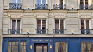 La façade d’un immeuble sur laquelle on peut lire l’inscription « MAISON BARBÈS » au-dessus de l’entrée.