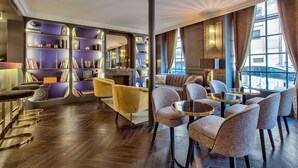 Un espace de détente moderne doté d’un bar, de sièges et d’étagères à livres.