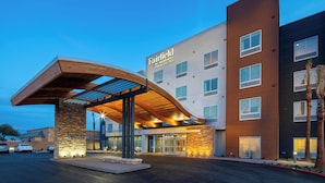 A Fairfield by Marriott hotel with a modern design, featuring a curved entrance canopy and a stone facade.