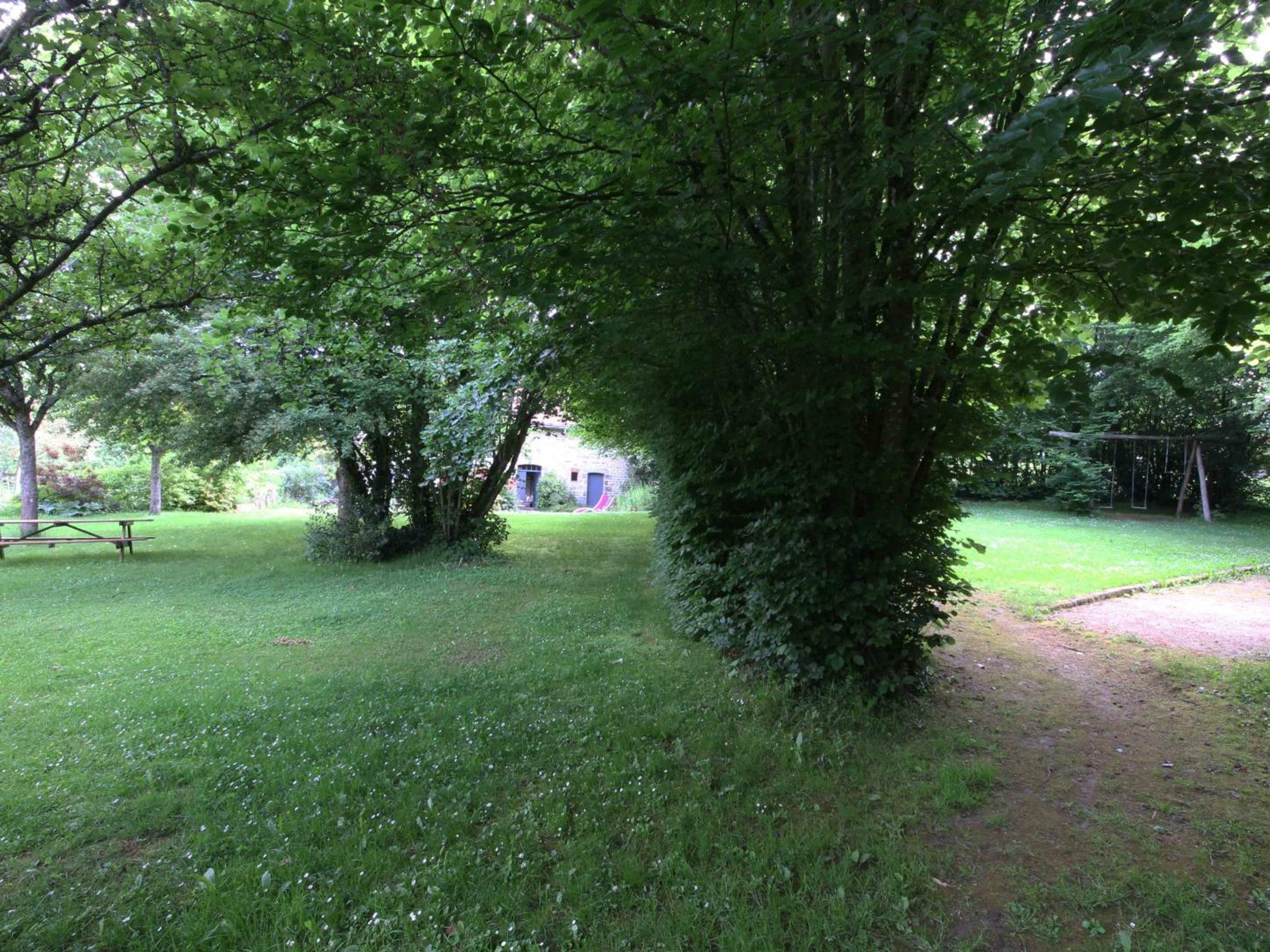 Ett grönområde med en picknickbord och en gunga.