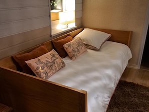 A wooden bed with white bedding and two patterned pillows. - Spacious house, pets allowed - 10 guests (La Sauvagère)