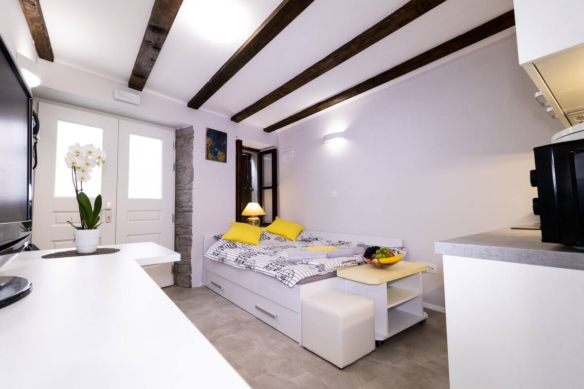 Een moderne slaapkamer met een bed, nachtkastje en een bureau.