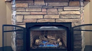 A stone fireplace with a star decoration above it and five candles on the mantel. - McCall Cabin in Spring Mountain Ranch- Shared Pool (McCall)