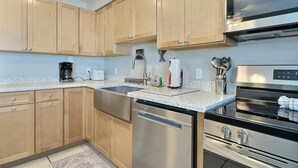 A modern kitchen with wooden cabinets, stainless steel appliances, and a dishwasher. - Enjoy the Siesta Key Beach Life to the fullest! Beach AND Pool Access (Siesta Key)