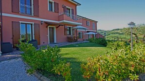 A two-story house with a balcony, a patio with outdoor furniture, and a well-maintained garden. - Apartment Alloro - 2 bedrooms, pool, A/C, wifi, pets, see, Marche (Candelara di Pesaro)
