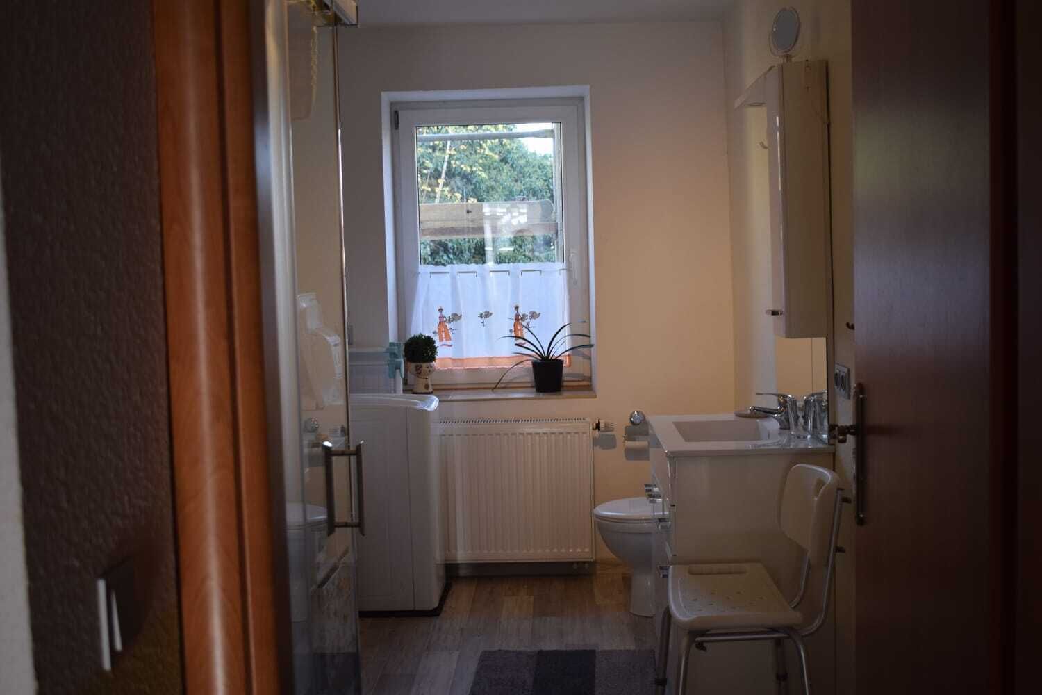 A small, compact bathroom with a toilet, sink, and window.