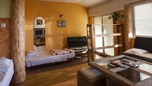 A cozy room with a bed, a chair, a table, and a potted plant.