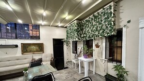 A room with a sofa, a dining table with chairs, a small potted plant, and a hanging plant on the wall. - OttomanZade (Istanbul)