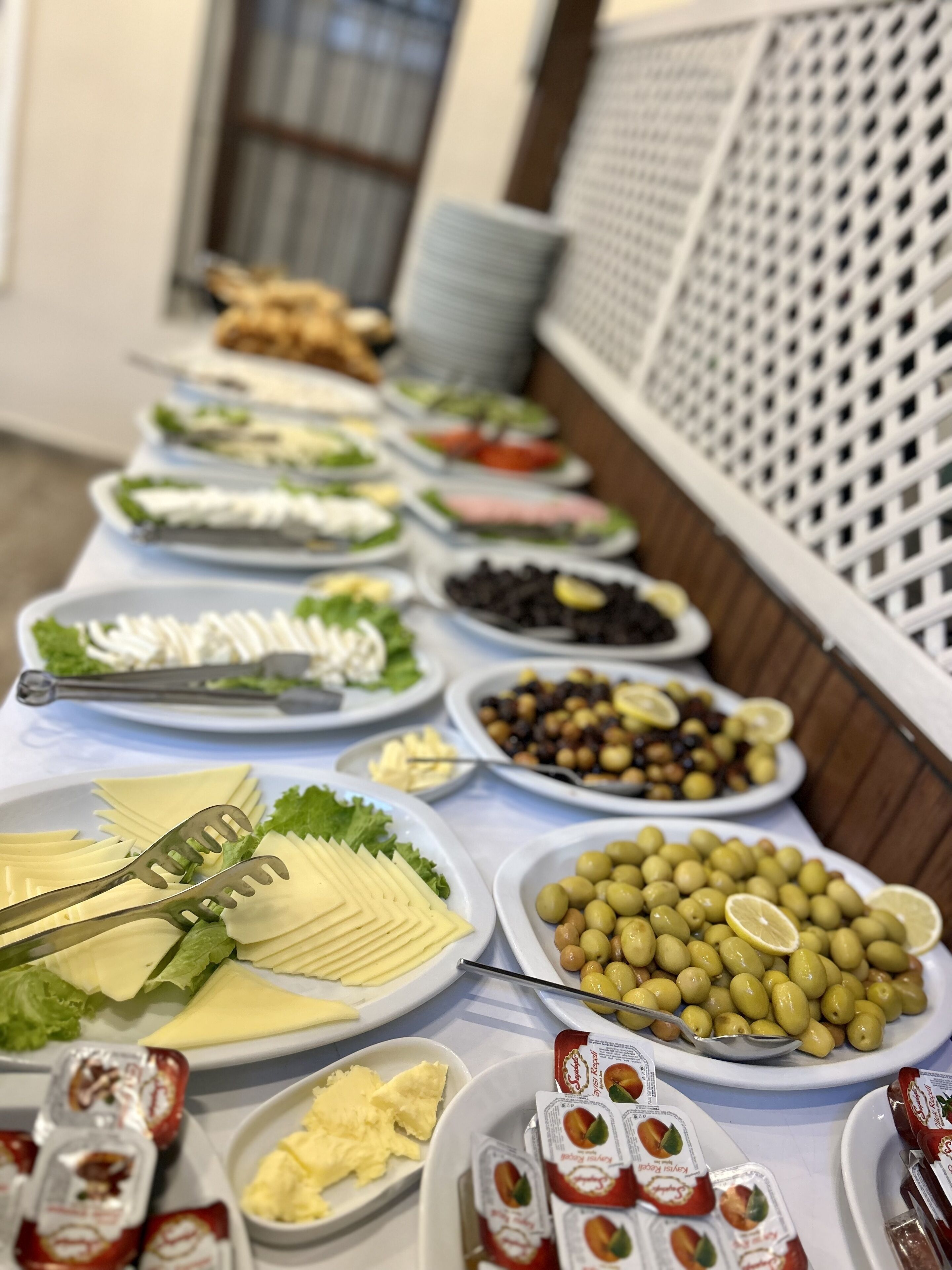 A buffet table with various food items including cheese, olives, and condiments.