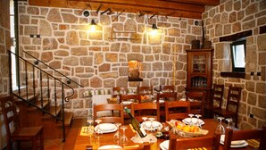 Ein Essbereich mit Steinwand, Holzmöbeln und einer Treppe.