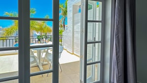 An open balcony with a view of palm trees and a pool. - Apartamentos Parque del Sol (Adeje)