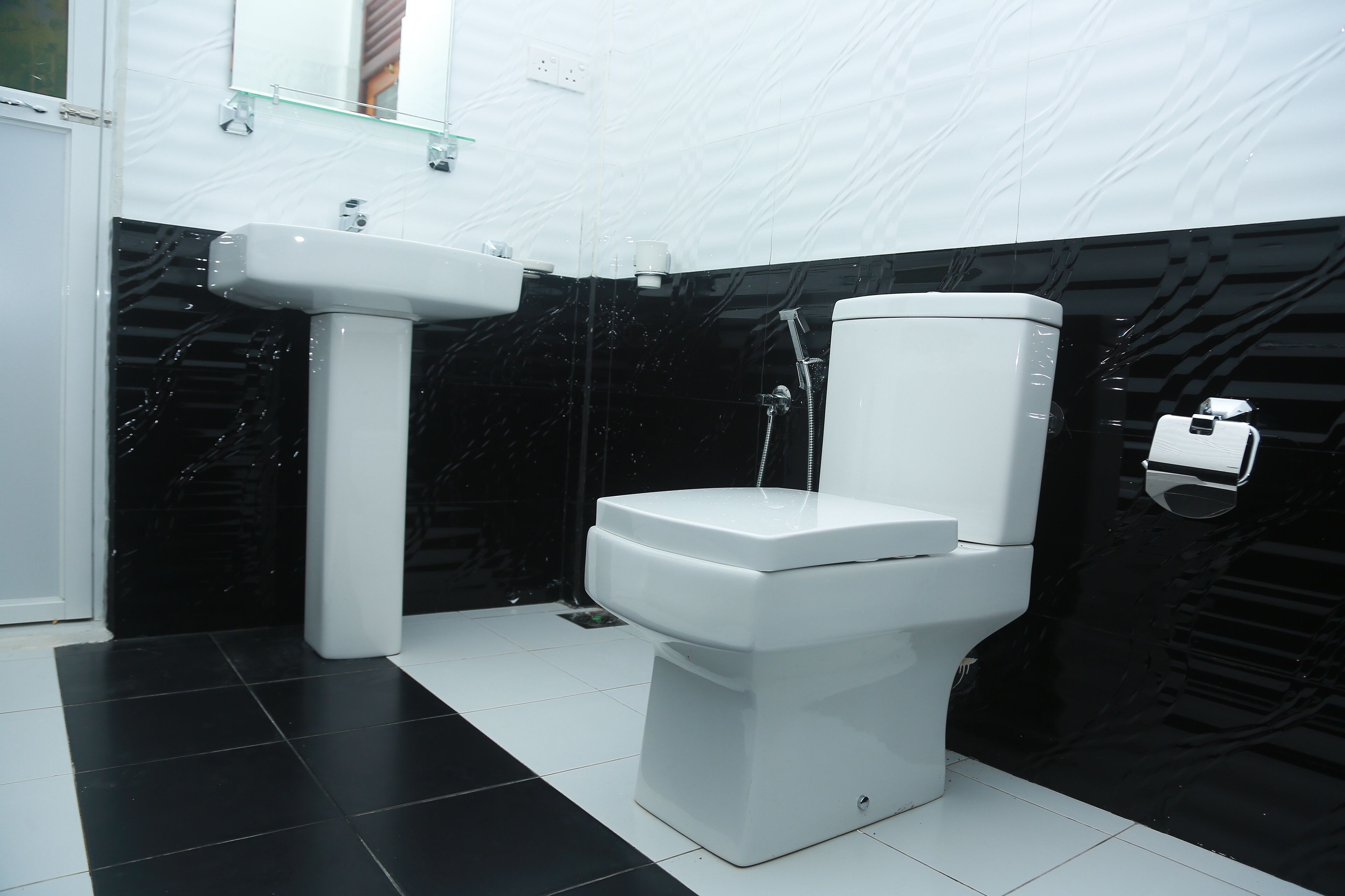 A modern bathroom with a toilet, sink, and shower.