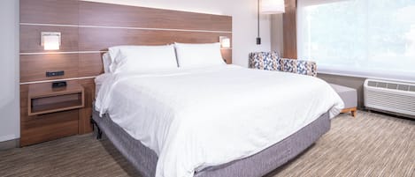 Una habitación de hotel con una cama grande, una mesita de noche, una lámpara, una ventana con vistas y un calentador incorporado.