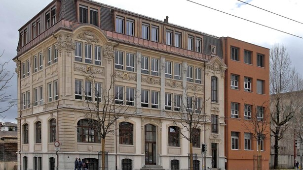 Een historisch gebouw met een klassieke architectuur, gekenmerkt door versierde details en grote ramen.