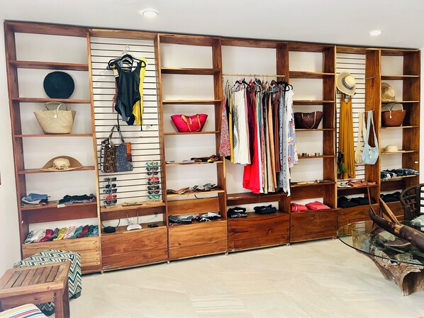 A boutique with wooden shelving displaying clothing, accessories, and shoes. - Hotel Casa Cielo (El Cuyo)