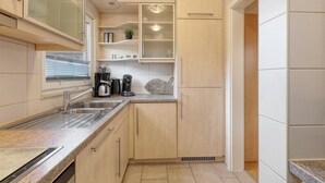 A compact kitchen with a sink, countertop, and cabinets. - Holiday house near Anne (sauna, forest, lake) (Kirchheim)