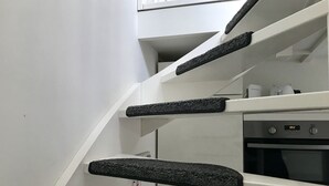 A modern kitchen with white cabinets, a built-in oven, and a digital clock displaying 10:52. - Vacation home with 3 bedrooms, furnished. Garden, 2 bathrooms, 2 kitchens, 200 meters from the beach (Egmond aan Zee)