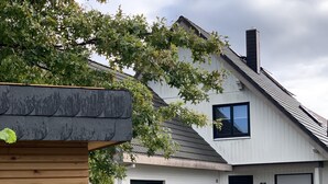 A two-story house with a brick facade, a black door, and a garage.