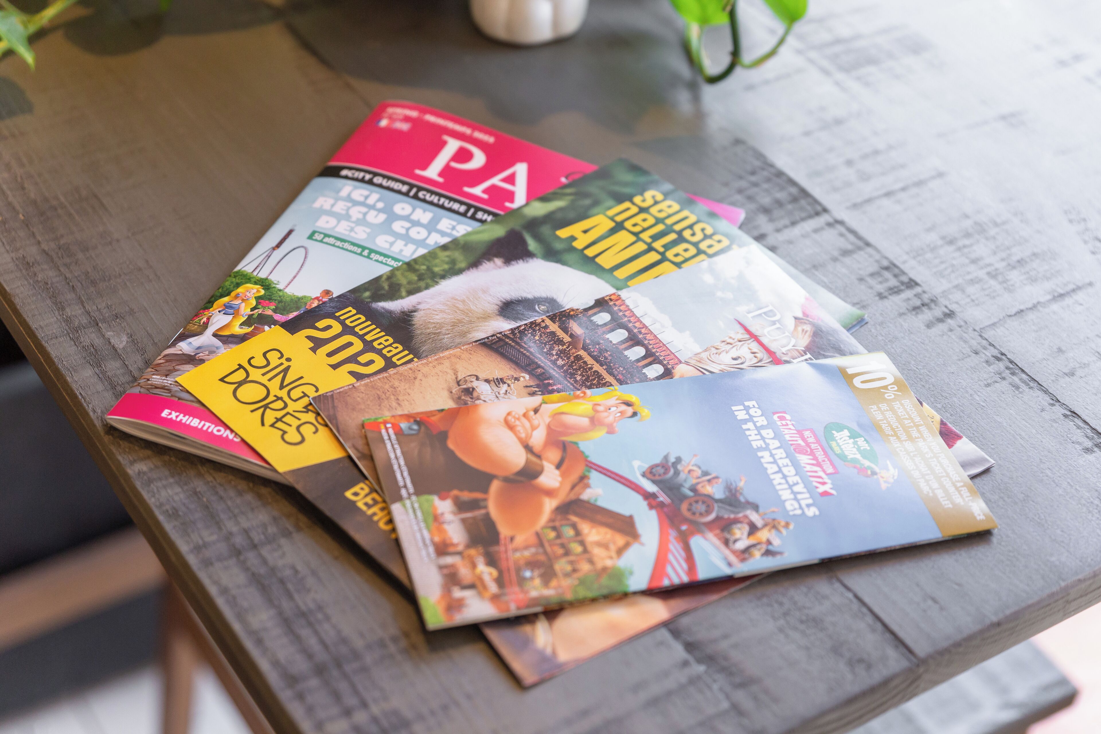 Una pila de revistas sobre una mesa de madera.