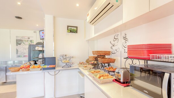 Un espace cuisine moderne équipé d’un four à micro-ondes, d’un grille-pain et présentant divers produits alimentaires.