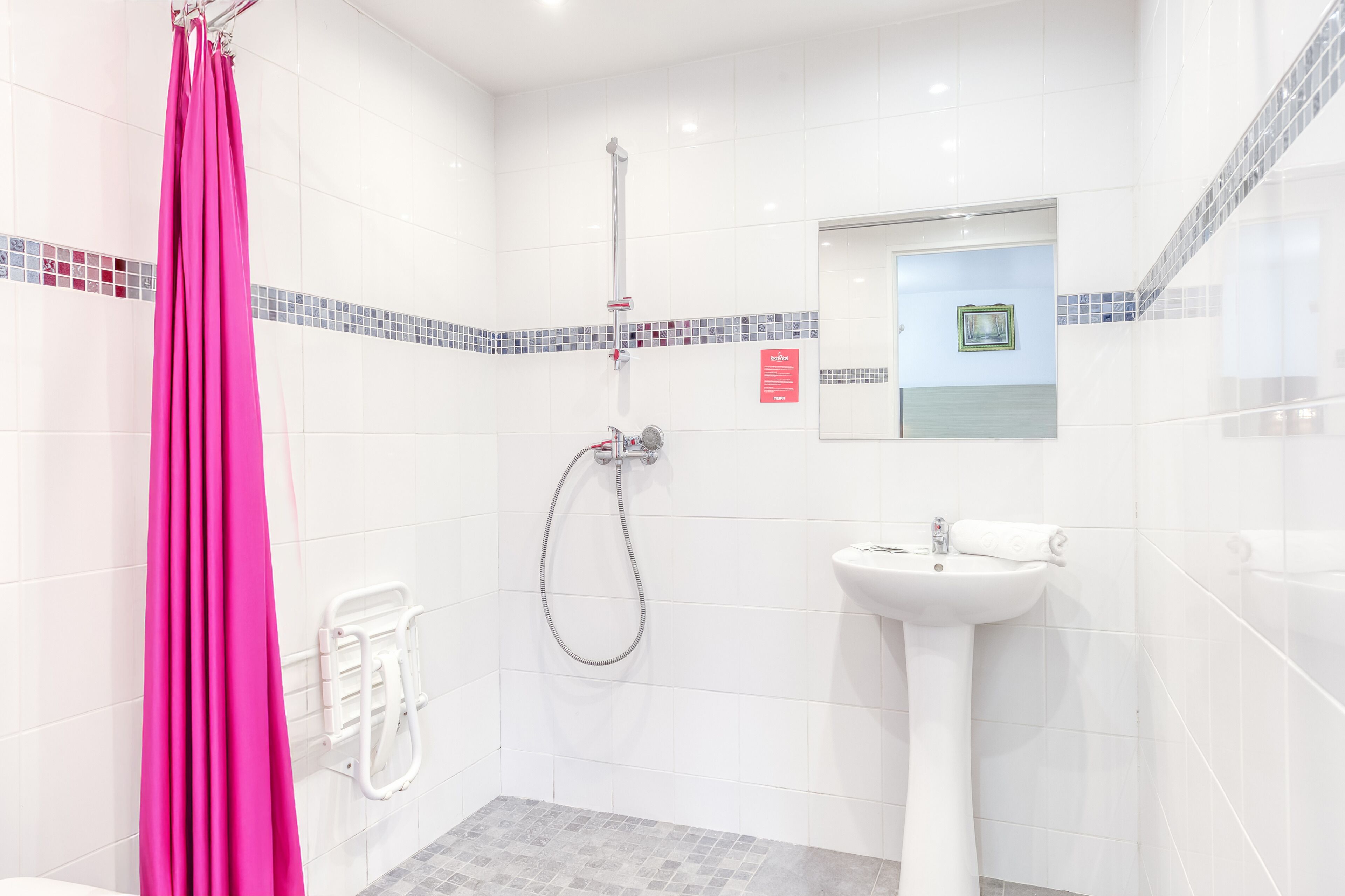 Un baño con ducha, lavabo y cortina rosa.