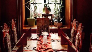 A dining area with a long table set for a meal, flanked by chairs, with a window in the background. - Hotel & Restaurant Peking (Riesa)