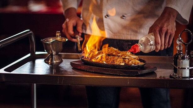 A chef cooking with a flame on a table. - Hotel & Restaurant Peking (Riesa)