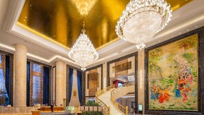 A grand lobby with a marble floor, a grand staircase, and a large traditional painting. - Oriental Ventura Hotel (Lishui)